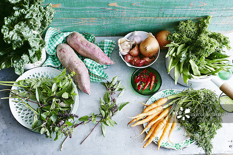 新鲜薄荷、甘薯、小胡萝卜、辣椒、洋葱、大蒜、葱、青豆、羽衣甘蓝和银甜菜静物图片素材