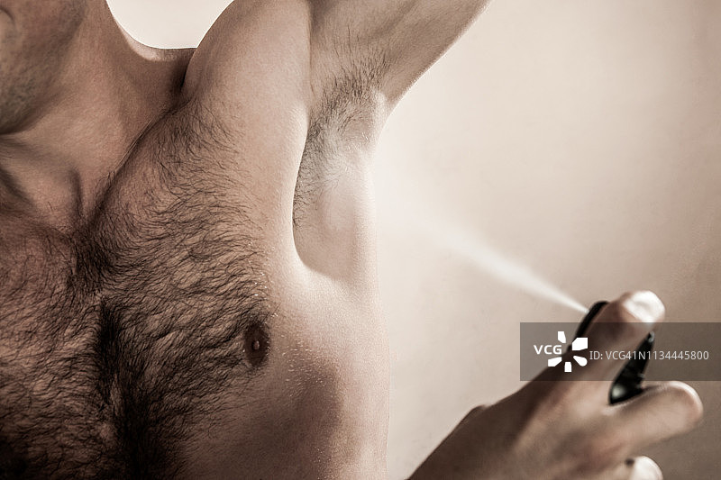 喷洒除臭剂的中年男人摄影棚拍摄图片素材