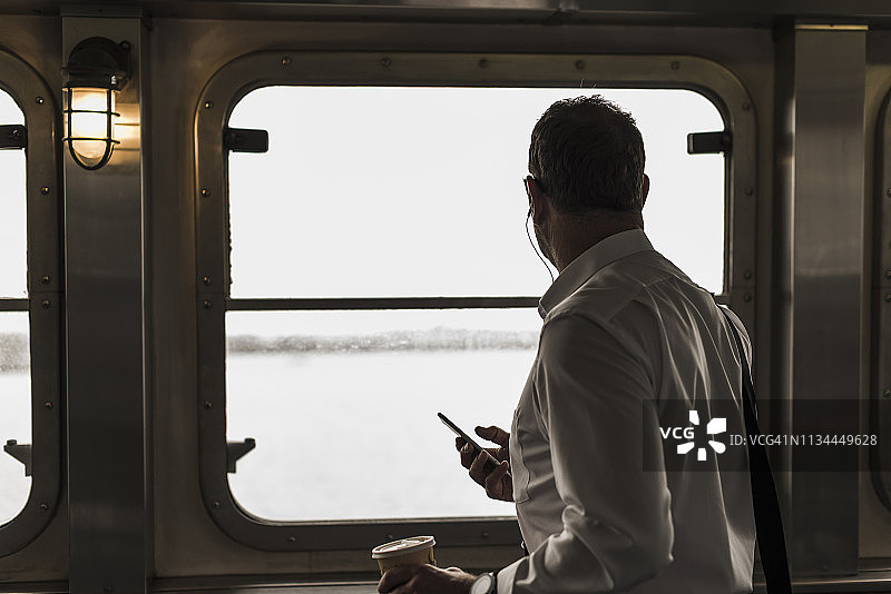 在渡轮上眺望窗外的商人图片素材