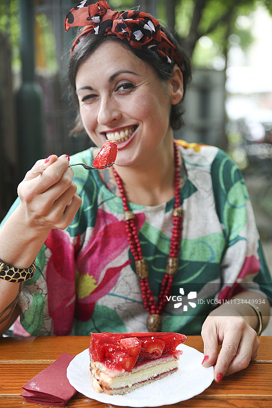 女人在街边咖啡馆吃草莓蛋糕图片素材