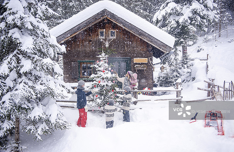 奥地利阿尔滕马克特-措岑泽：家人在木屋装饰圣诞树图片素材