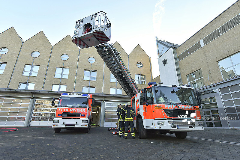 两名消防员在消防车旁准备行动图片素材