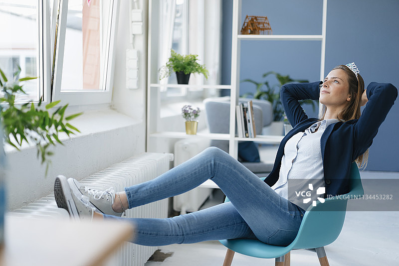 有抱负的年轻女子佩戴皇冠庆祝成就图片素材