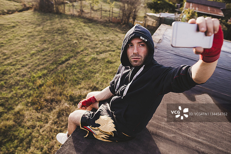 拳击手坐在屋顶阳台上自拍图片素材