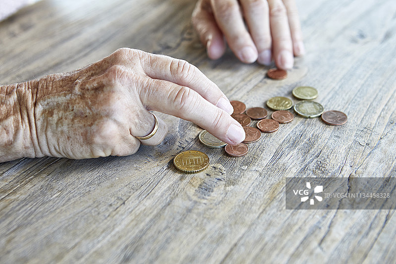 年长女人数硬币的特写图片素材