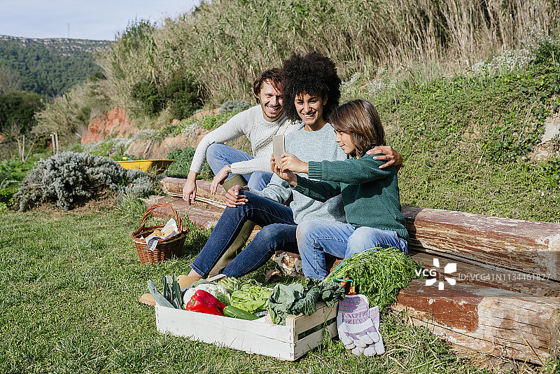 幸福的家庭在收获蔬菜后休息，自拍图片素材