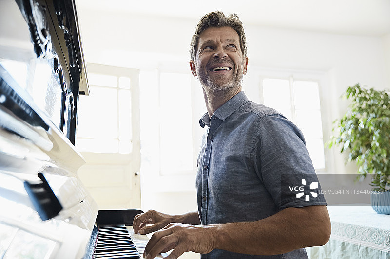 中年男人在家弹钢琴图片素材