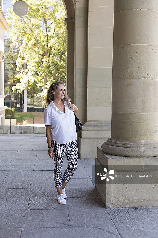 在城市里微笑的中年妇女图片素材