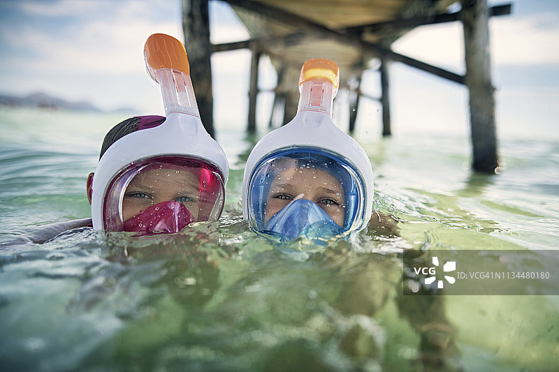 在码头下海中浮潜的男孩图片素材