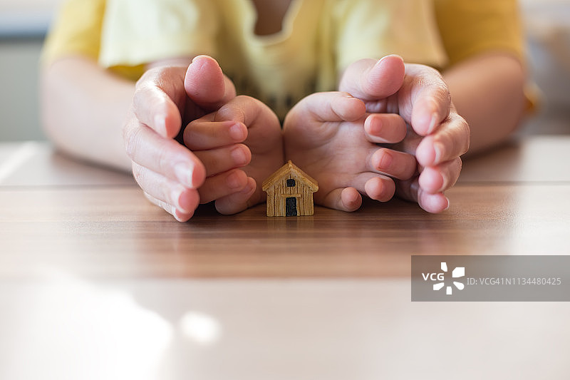 房地产和家庭住宅概念——女性手持房屋模型图片素材