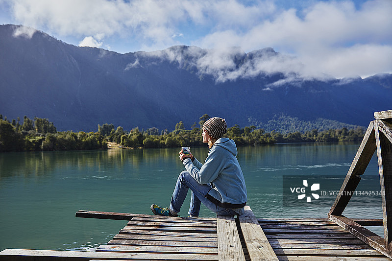 智利柴滕：罗塞洛特湖，坐在码头上手持杯子的女性图片素材