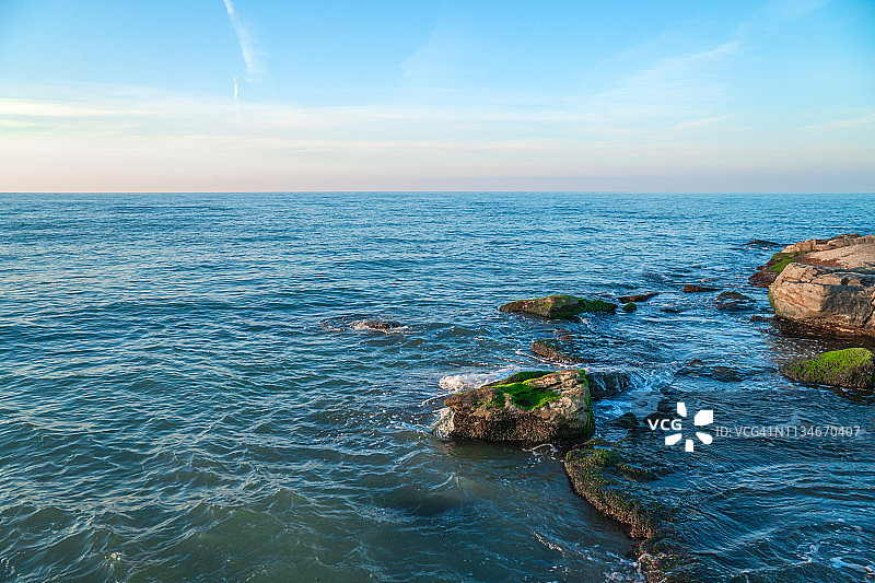 色彩斑斓的海岸与绿色海藻，浪花飞溅图片素材