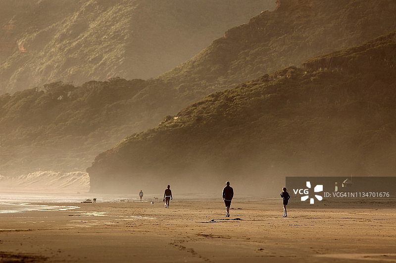 人们在贝索斯海滩日落时漫步图片素材