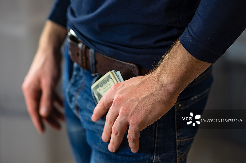 男人手持金钱，留有文本区域图片素材
