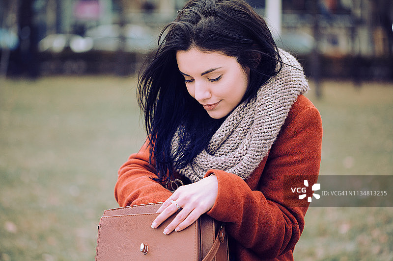 漂亮的女人在钱包里寻找东西图片素材