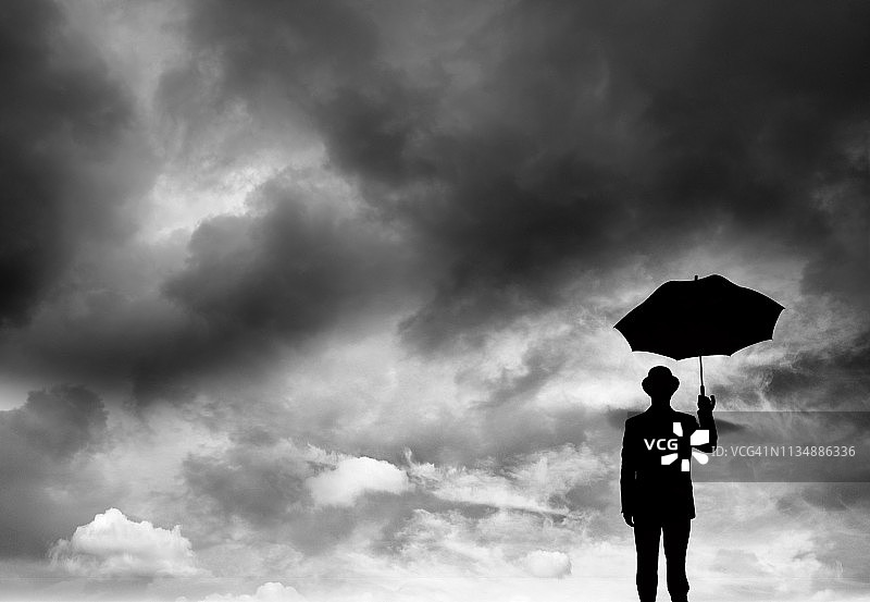 商人拿着雨伞和乌云图片素材