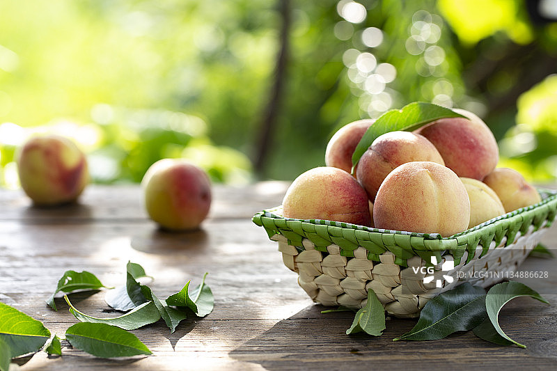 成熟的红润有机桃子。棕色木桌上的收获。图片素材