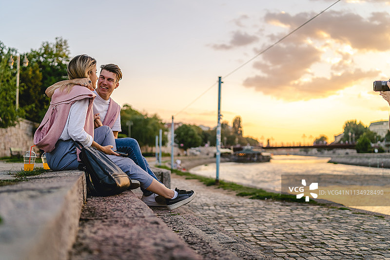 年轻夫妇坐在河边图片素材