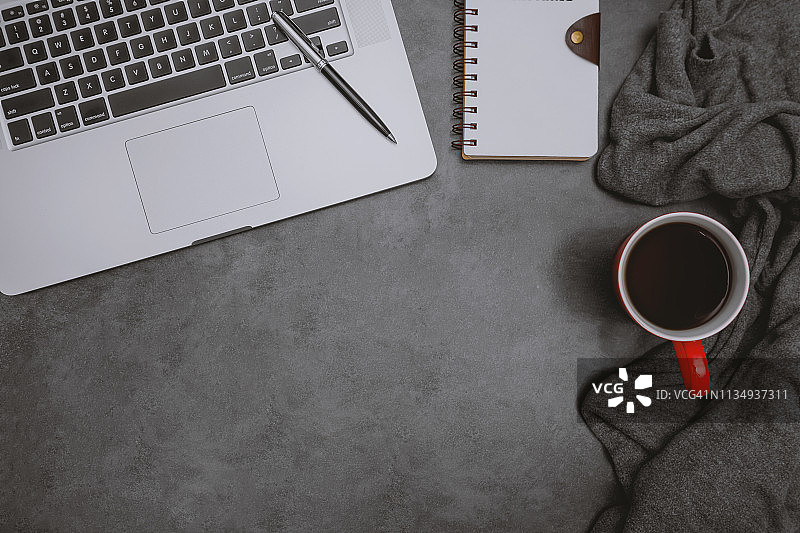 家庭办公桌上的笔记本电脑、笔记本和咖啡杯图片素材