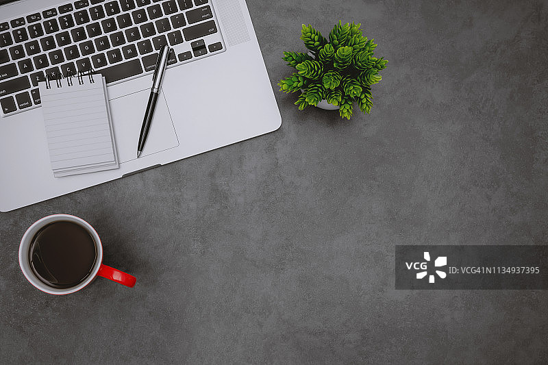 家庭办公桌上的笔记本电脑、笔记本和咖啡杯图片素材