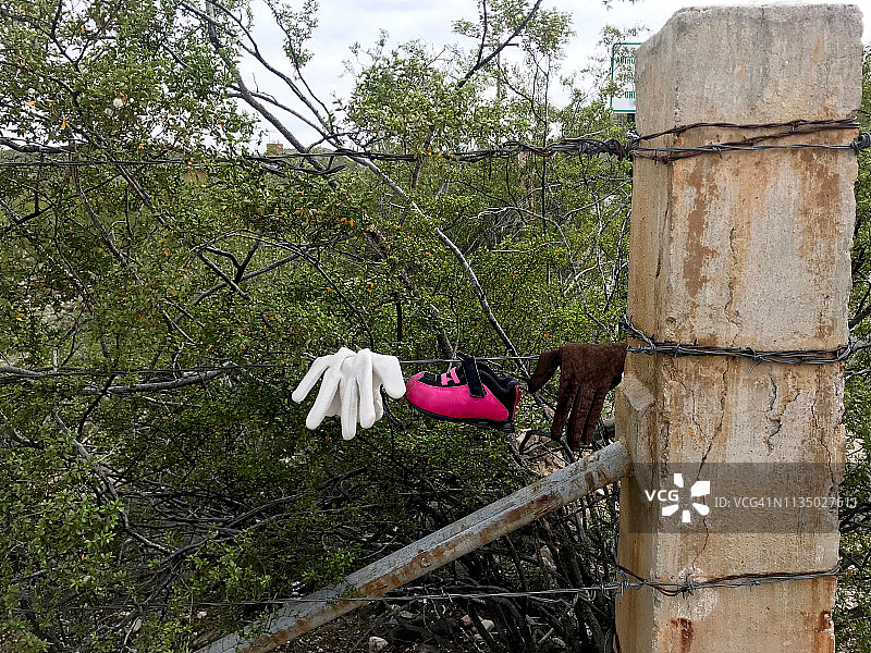 手套和婴儿鞋挂在铁丝网上图片素材