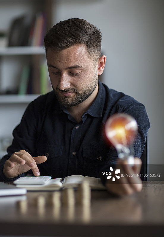 商业会计与储蓄，手持灯泡概念金融背景图片素材