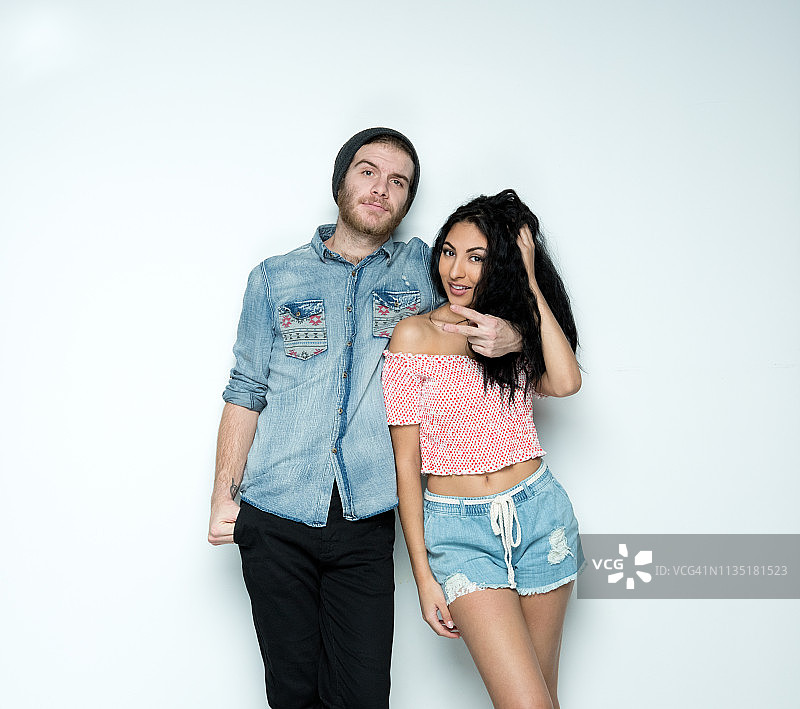 可爱的时髦年轻情侣站在白墙前图片素材