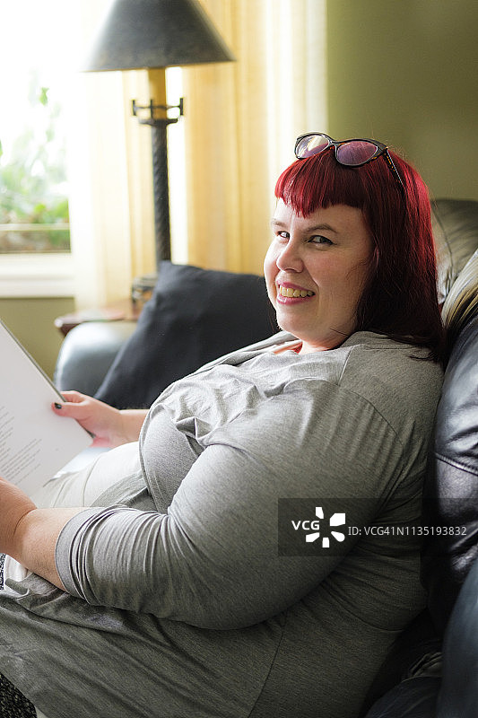 加大码女性在沙发上看书图片素材