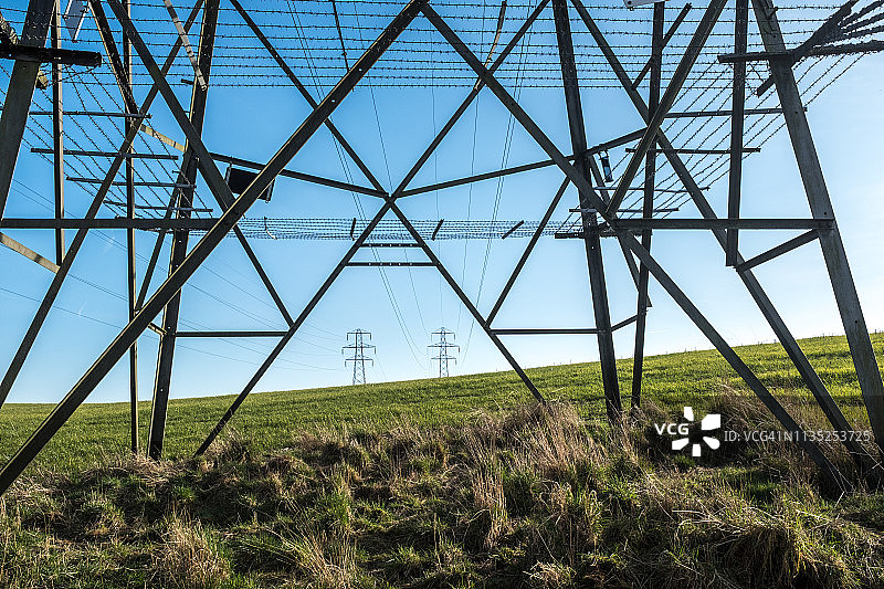 英国田野中的输电塔和电力线图片素材