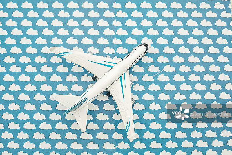 云层背景中的模型飞机：留白图片素材