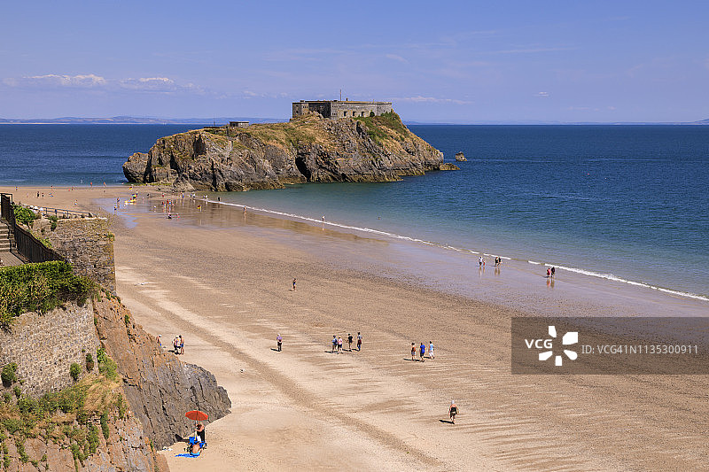 夏季阳光明媚的蓝天下，英国威尔士彭布罗克郡滕比城堡海滩和圣凯瑟琳岛图片素材