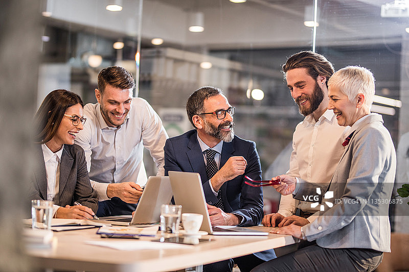 快乐的商务团队在办公室工作时进行交流图片素材