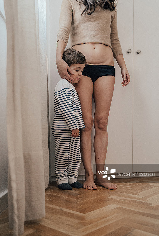 母亲向孩子展示剖腹产疤痕图片素材