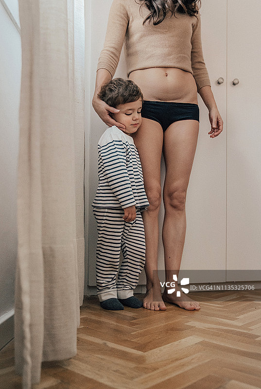 母亲向孩子展示剖腹产疤痕图片素材