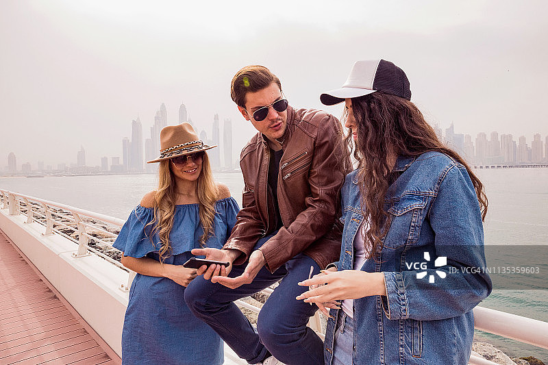 朋友们用智能手机讨论社交媒体图片素材