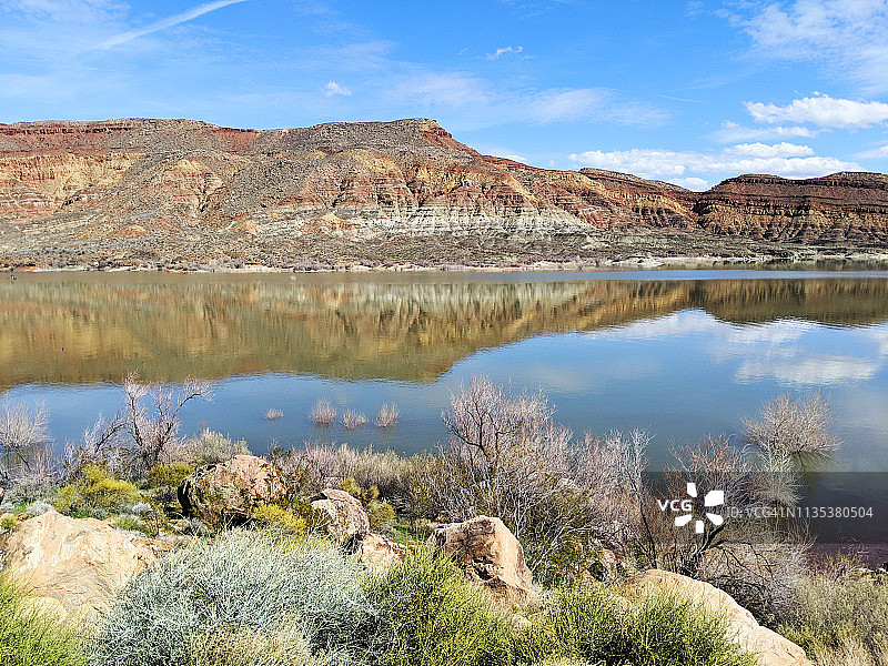 犹他州飓风市附近鹌鹑溪州立公园水库的红色岩石和悬崖的倒影图片素材