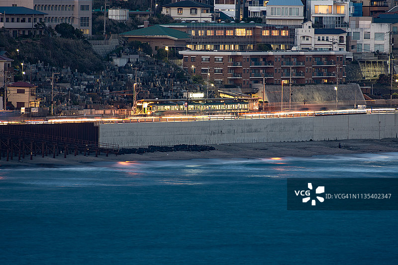 日本镰仓市行驶在太平洋沿岸的当地火车图片素材