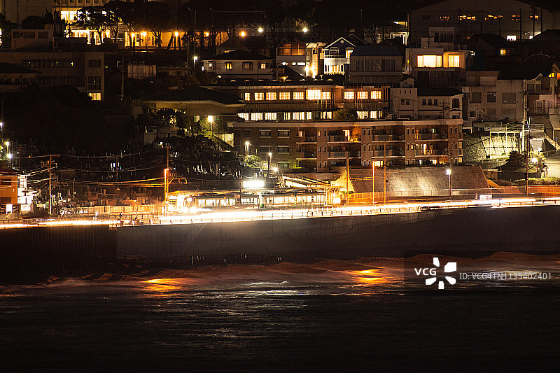 日本镰仓市行驶在太平洋沿岸的当地火车图片素材