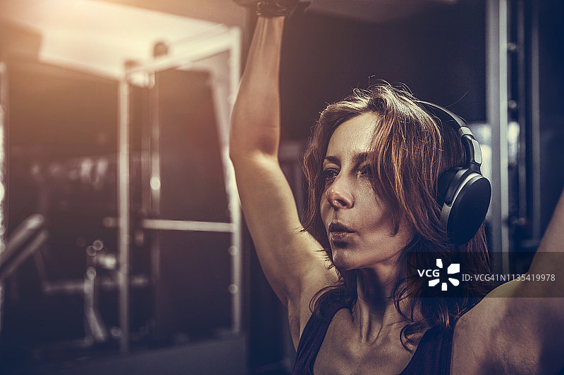 在健身房用杠铃锻炼的女人图片素材