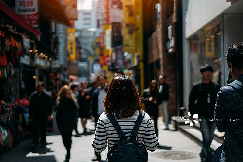 在明洞街头市场旅行购物的年轻亚洲女性图片素材