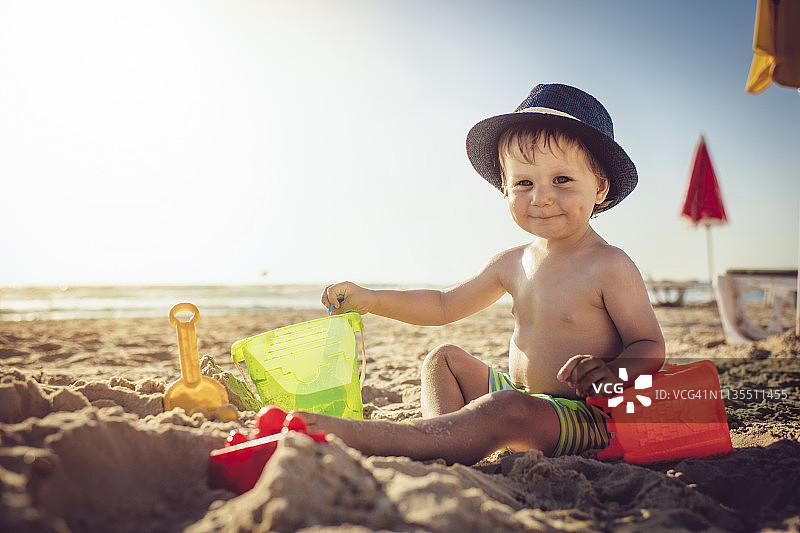 小男孩在沙滩上堆沙堡图片素材