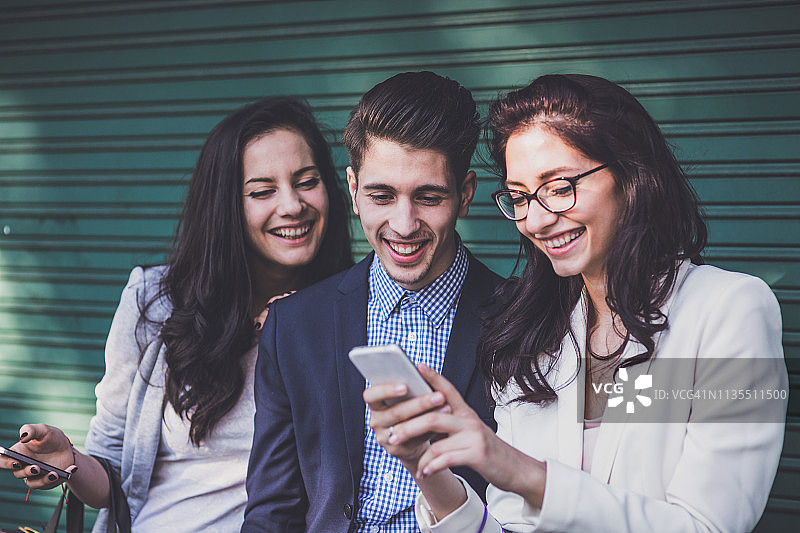 快乐的朋友们在手机上浏览图片素材