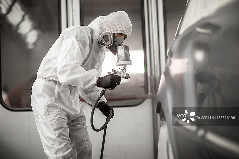 喷漆技师在车身车间喷漆房为汽车部件喷漆图片素材