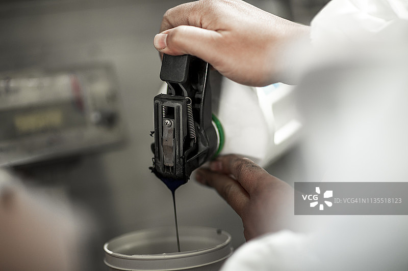 汽车喷漆技术员倾倒和混合油漆图片素材