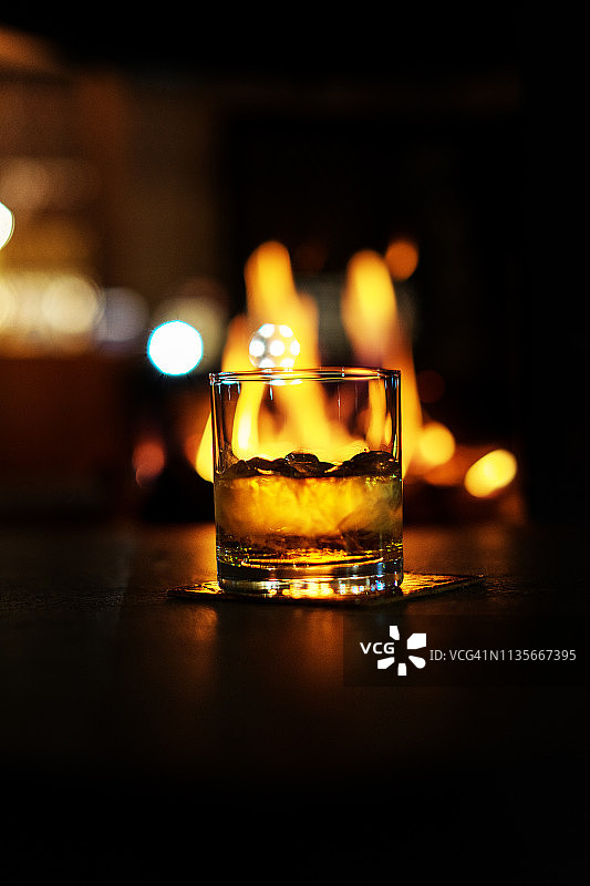 威士忌冰块置于威士忌杯中，置于木柴背景上特写图片素材