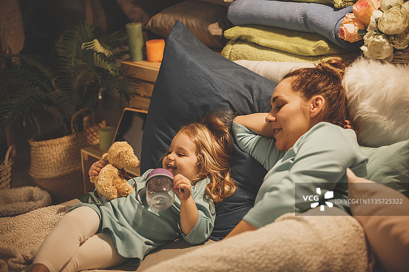 女婴在床上玩泰迪熊图片素材