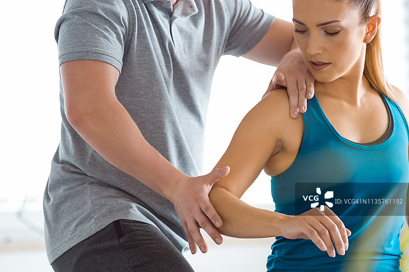 理疗师在康复中心检查年轻女子图片素材