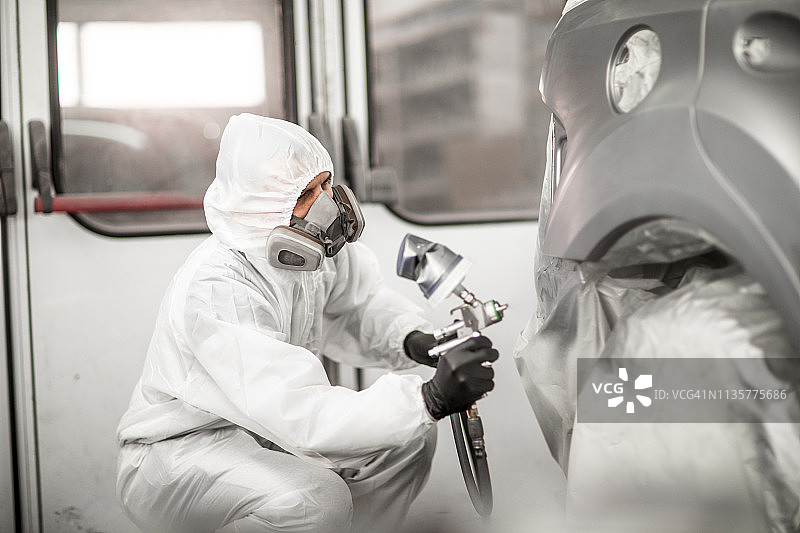 喷漆技师在车身车间喷漆房为汽车部件喷漆图片素材