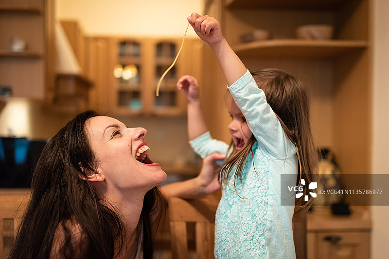 母亲张开嘴吃意大利面图片素材