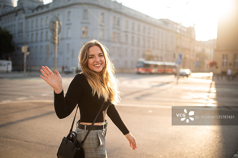 快乐的女人路过时向镜头挥手图片素材